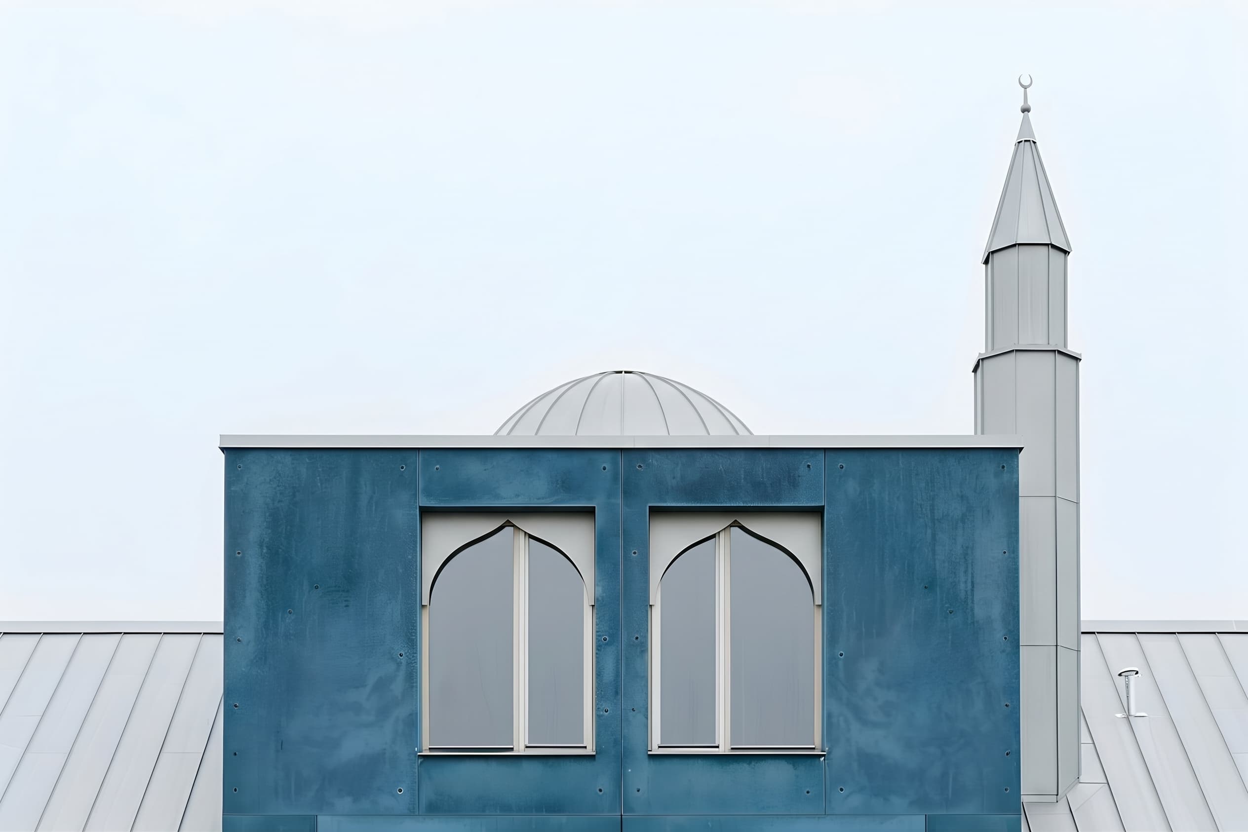 Blue panelled prayer hall of Fjordlys Mosque with its shallow dome and slender minaret
